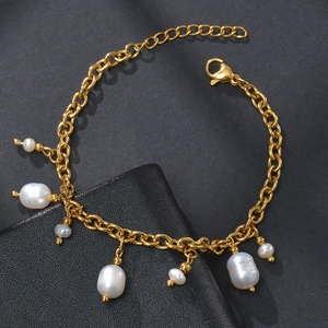 Detailed view of golden link chain bracelet with baroque freshwater pearl charms