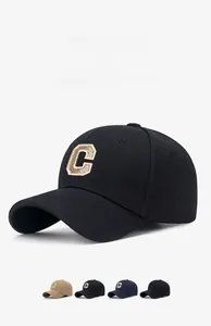 Detail view of large gold embroidered C logo on high quality twill fabric baseball cap