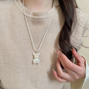 Close-up of a model wearing the colorful resin bear pendant necklace with a white rope cord