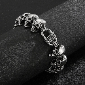 Detail of vintage silver skull links and clasp on a punk style stainless steel bracelet