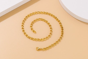 Nahaufnahme der flachen Gliederkette in Gold mit Karabinerverschluss auf Dekoelementen