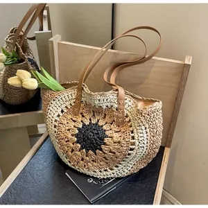 Detail of sunflower crochet paper rope tote bag with leather straps on a wooden chair