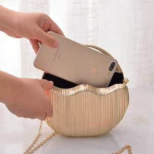 Golden pleated shell evening clutch bag with chain strap and interior phone storage capacity