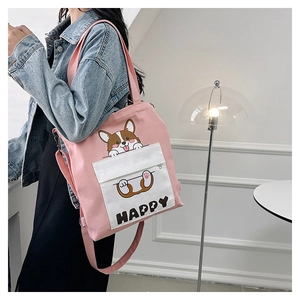 Detail shot of the pink canvas tote featuring a Corgi cartoon and Happy print