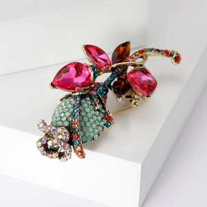 Macro detail of vintage rose brooch with colorful rhinestones on a white stand