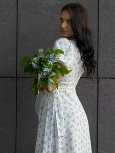 Detail of white cotton floral maxi dress with puff sleeves and waist tie design