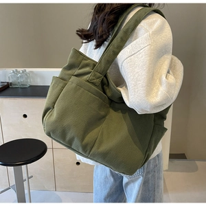Détails de la texture du sac en velours côtelé vert et poche latérale spacieuse