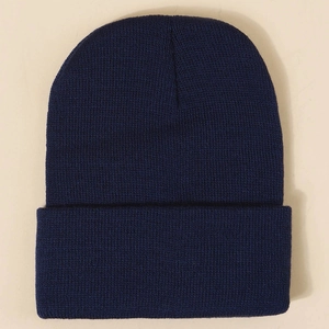 Detailed close-up of dark blue ribbed knit beanie featuring fine texture and wide fold