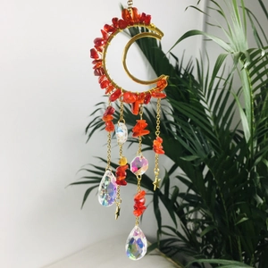 Detail of moon-shaped suncatcher with red amethyst stones and crystal teardrop pendants