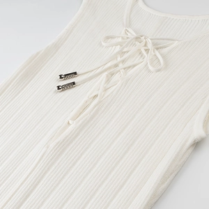 Close-up of white ribbed knit top featuring lace-up front with silver metal aglets