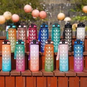 Outdoor 32oz gradient sports water bottle with straw and time marker displayed on wood