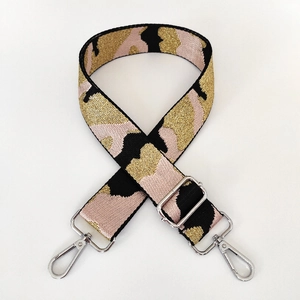 Detail of adjustable camouflage nylon bag strap with polished silver metal swivel hooks