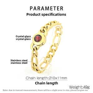 Detail of gold Cuban link chain bracelet featuring a round red crystal inset on stainless steel