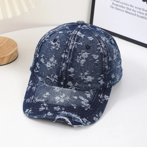 Distressed blue denim baseball cap with floral wash pattern and frayed brim detail