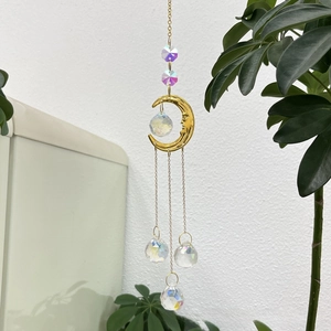 Detail of golden moon suncatcher with multi-faceted crystal balls for garden decor