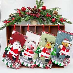 Close-up of four festive Christmas stockings with plush figures on a rustic wooden rack