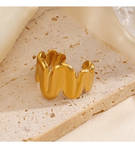 Detailed view of an 18K gold-plated wave-shaped open ring on a textured beige display