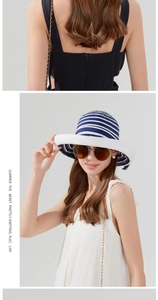 Close-up of blue and white striped summer straw bucket hat with wide white brim for women