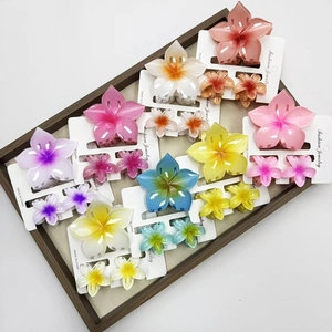 Rainbow petal hair claw clips in various colors displayed on a wooden jewelry tray