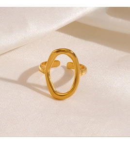 Detailed view of an adjustable golden oval ring on elegant cream silk fabric