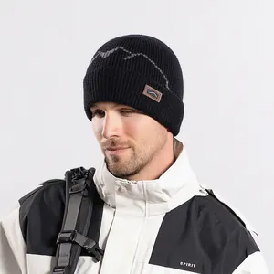 Black winter knit beanie with mountain pattern and fleece lining for outdoor cycling