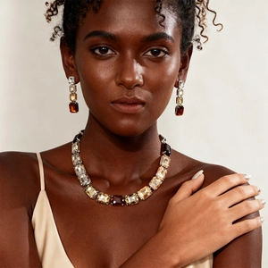 Close-up of three-piece jewelry set featuring rectangular gradient crystals on model