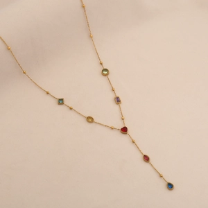 Detail of a golden Y-shaped necklace featuring colorful geometric crystals and heart charms