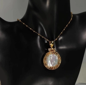 Vintage golden sun necklace with round mother of pearl pendant on a black bust
