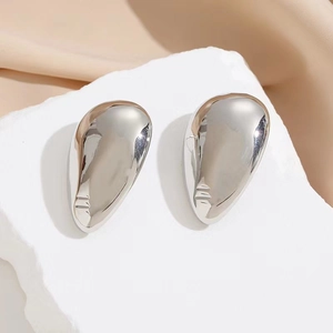 Minimalist silver abstract liquid metal face drop earrings on stone display stand