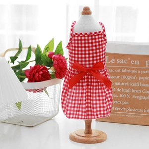 Detailed close-up of a red and white checkered pet dress with a large red ribbon bow