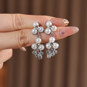 Détail de boucles d'oreilles en perles et strass argentés pour mariage et soirées