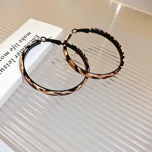 Exaggerated leopard print faux leather hoop earrings with black metal frames and silver needle