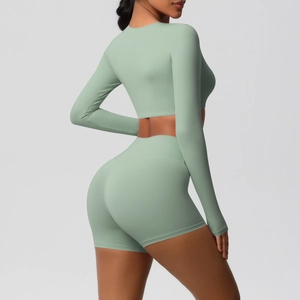 Side view of seamless sage green yoga set with long sleeve crop top and biker shorts