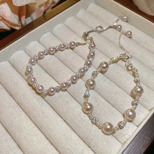 Gros plan sur bracelet en perles roses avec boules serties et fermoir argenté ajustable