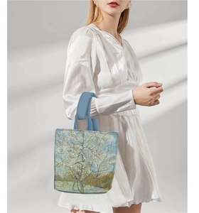 Detail of Van Gogh Almond Blossom print handbag held by model in natural sunlight
