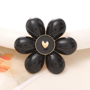 Colorful floral DIY accessory with black petals and a golden heart center decoration
