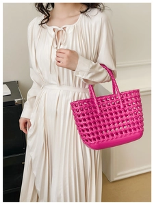 Detail of hot pink woven basket bag with hollow mesh design for summer travel