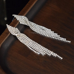 Sparkling silver rhinestone tassel earrings on a wooden tray for bridal wedding parties