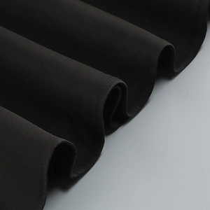 Nahaufnahme des eleganten schwarzen Kleiderstoffs mit feiner Textur und Nähten