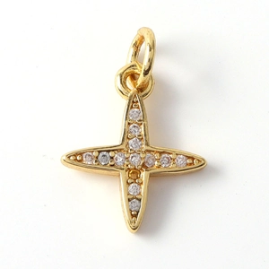 Close-up of golden cross pendant featuring sparkling zircon inlay and polished finish