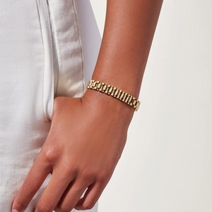 Close-up of a 18k gold-plated stainless steel watch-style link bracelet on a wrist
