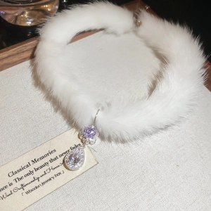 Detail of white plush faux fur choker with sparkling crystal and purple stone pendant