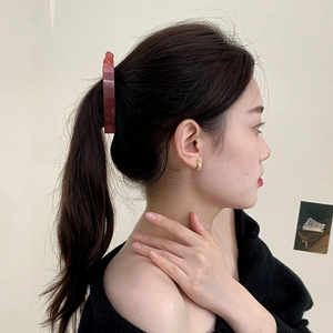 Minimalist dark brown tortoiseshell banana clip holding a ponytail on a model profile
