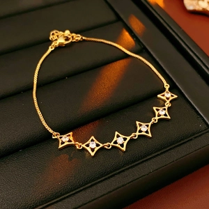 Détail d'un bracelet étoile plaqué or 18k avec zircons sur un support de bijoux noir