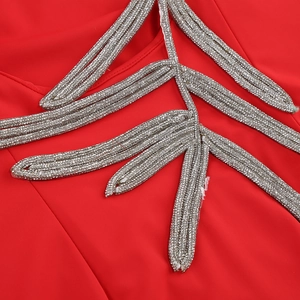 Close-up of silver leaf embroidery with sequins on red long-sleeved evening dress
