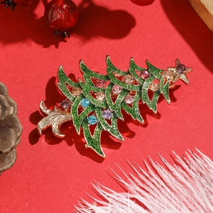 Detailed view of Christmas tree brooch with green enamel and multi-colored rhinestones