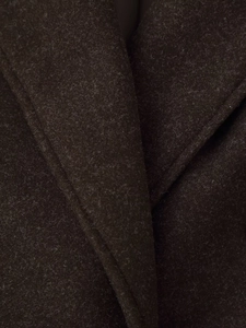 Close-up of wool blend fabric texture and notch lapel stitching on dark brown coat
