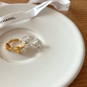 Elegant 925 sterling silver bow knot open rings in gold and silver finish on ceramic tray