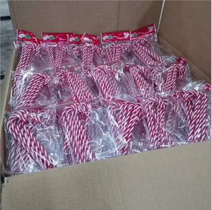 Detail of red and white acrylic Christmas candy canes in individual packaging for decor
