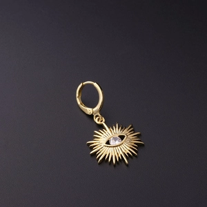 Detailed macro view of golden sunburst evil eye earring with a central clear zircon stone